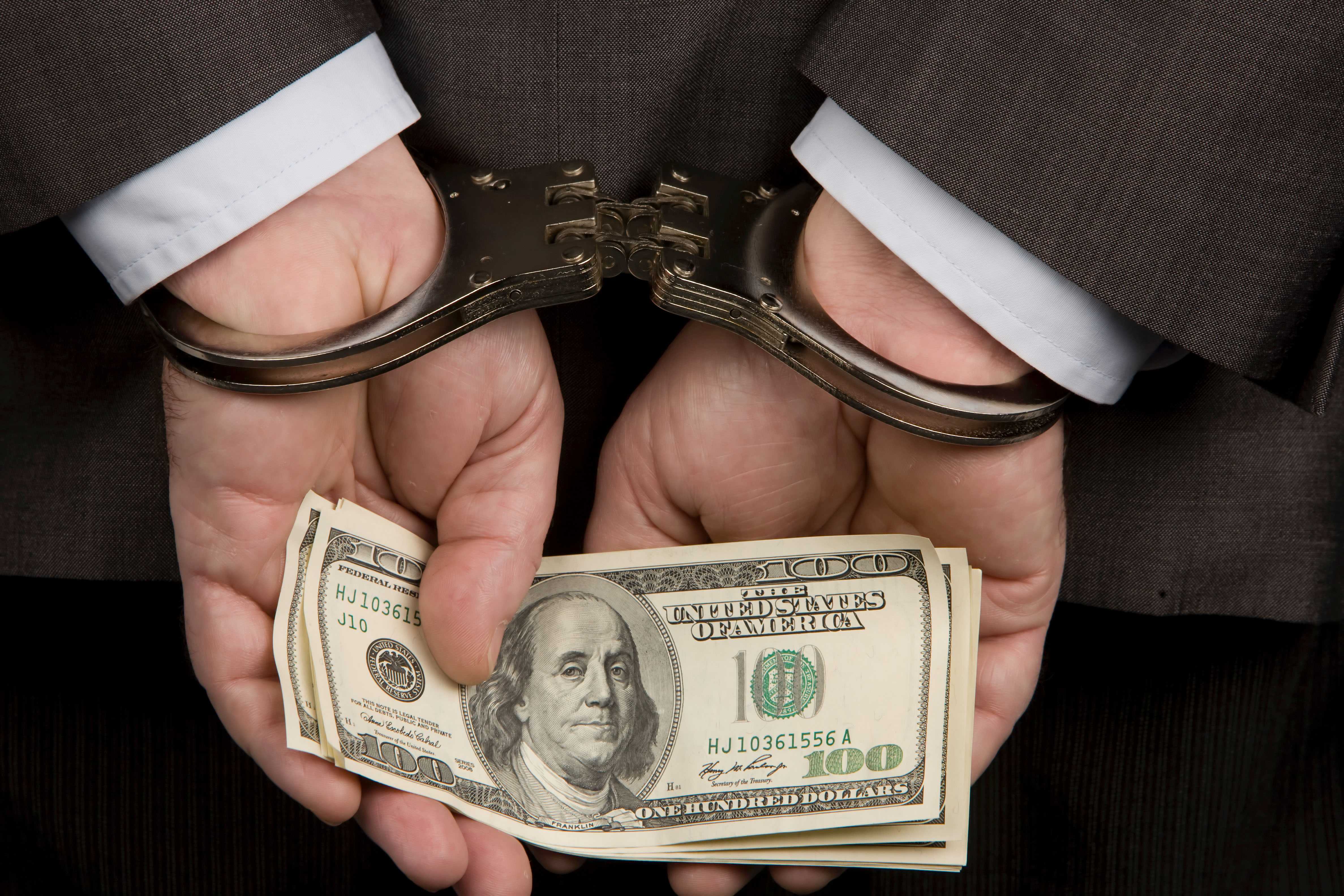 Требуют взятку. Руки в наручниках с деньгами. Коррупция деньги. Рука наручники доллары. Взятка деньги наручники.